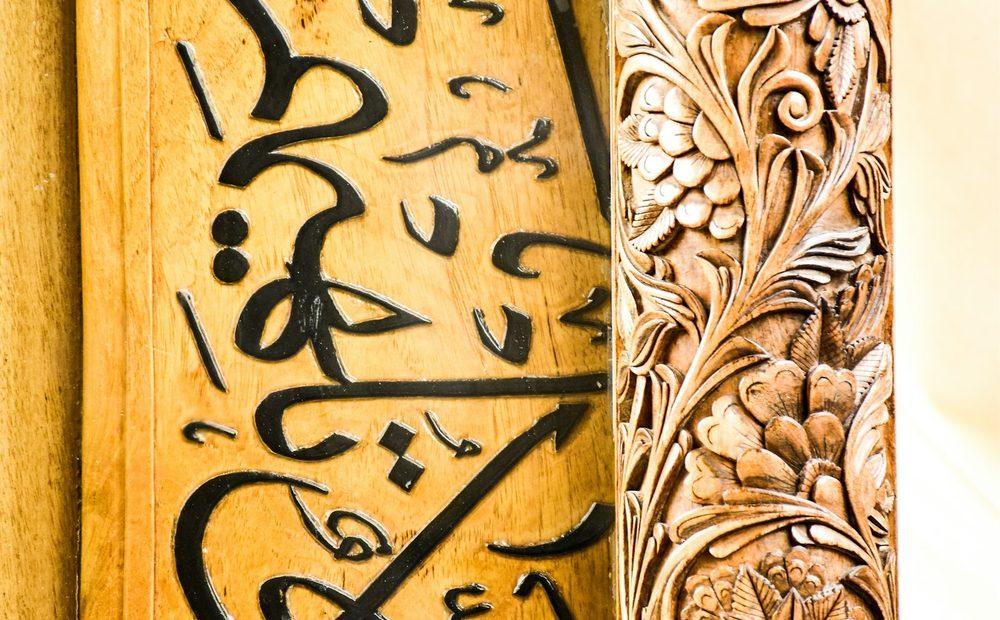 Carved Arabic calligraphy on a wooden panel