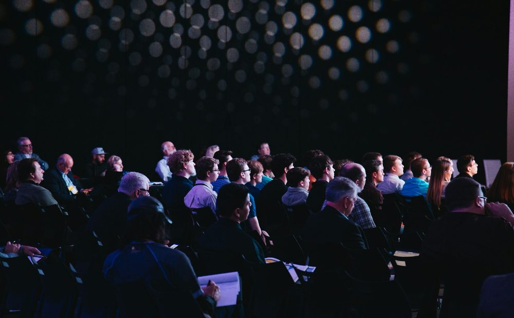 Senior audience seated in a darkened auditorium during a session